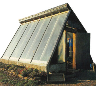 an a frame greenhouse on a concrete block with a bed of flowers along the&hellip;